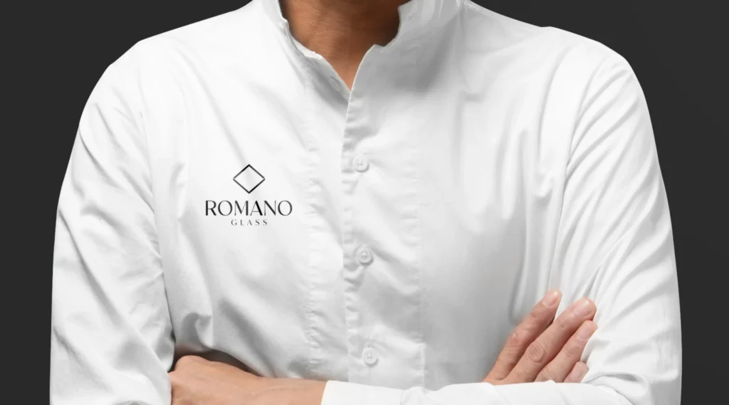 Empleado con camisa blanca bordada con el logotipo de Romano Glass, representando la identidad profesional de la marca.