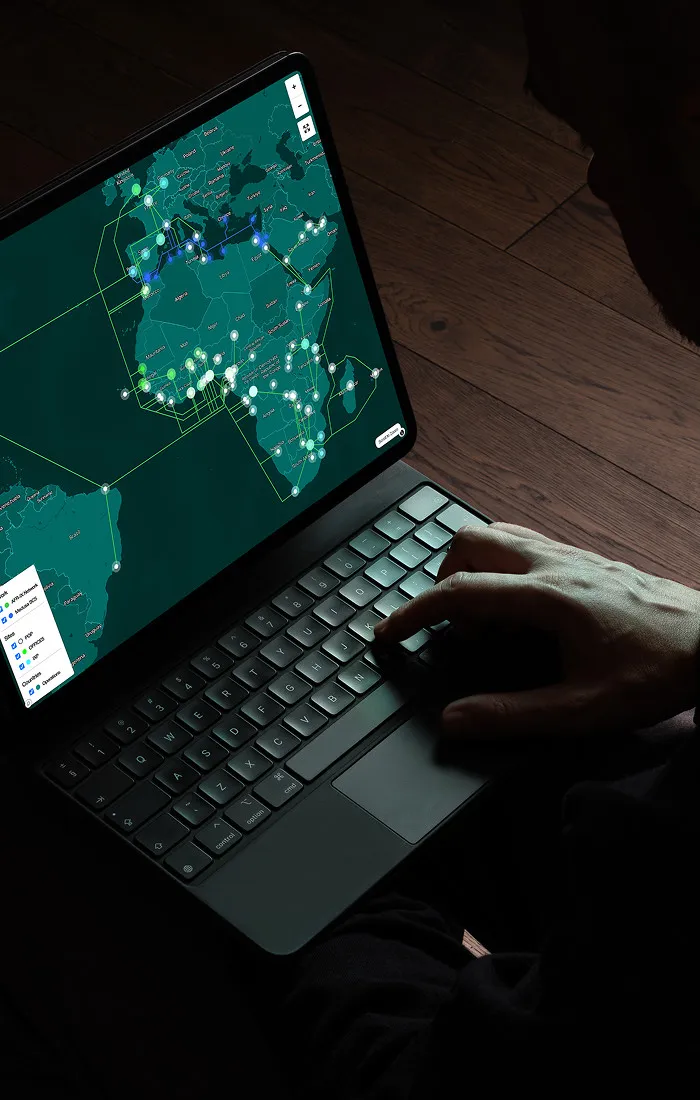 Diseño UI de panel de control para gestión de cables submarinos mostrando nodos de red y tráfico de datos en tiempo real en un portátil.