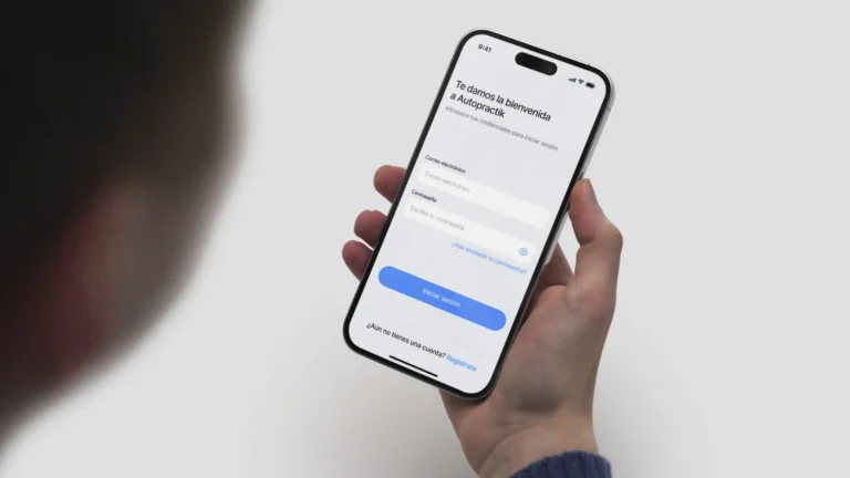 Mockup de la pantalla de inicio de sesión de la app Autopractik en un iPhone sostenido por un usuario.