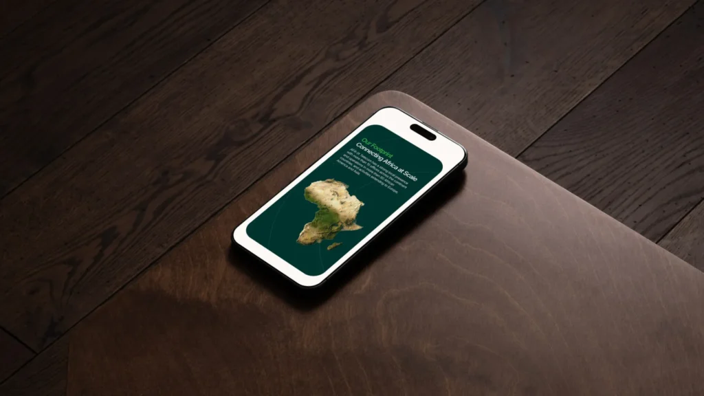 Interfaz móvil mostrando un mapa interactivo de cobertura de fibra óptica y conectividad en África sobre una mesa de madera oscura.